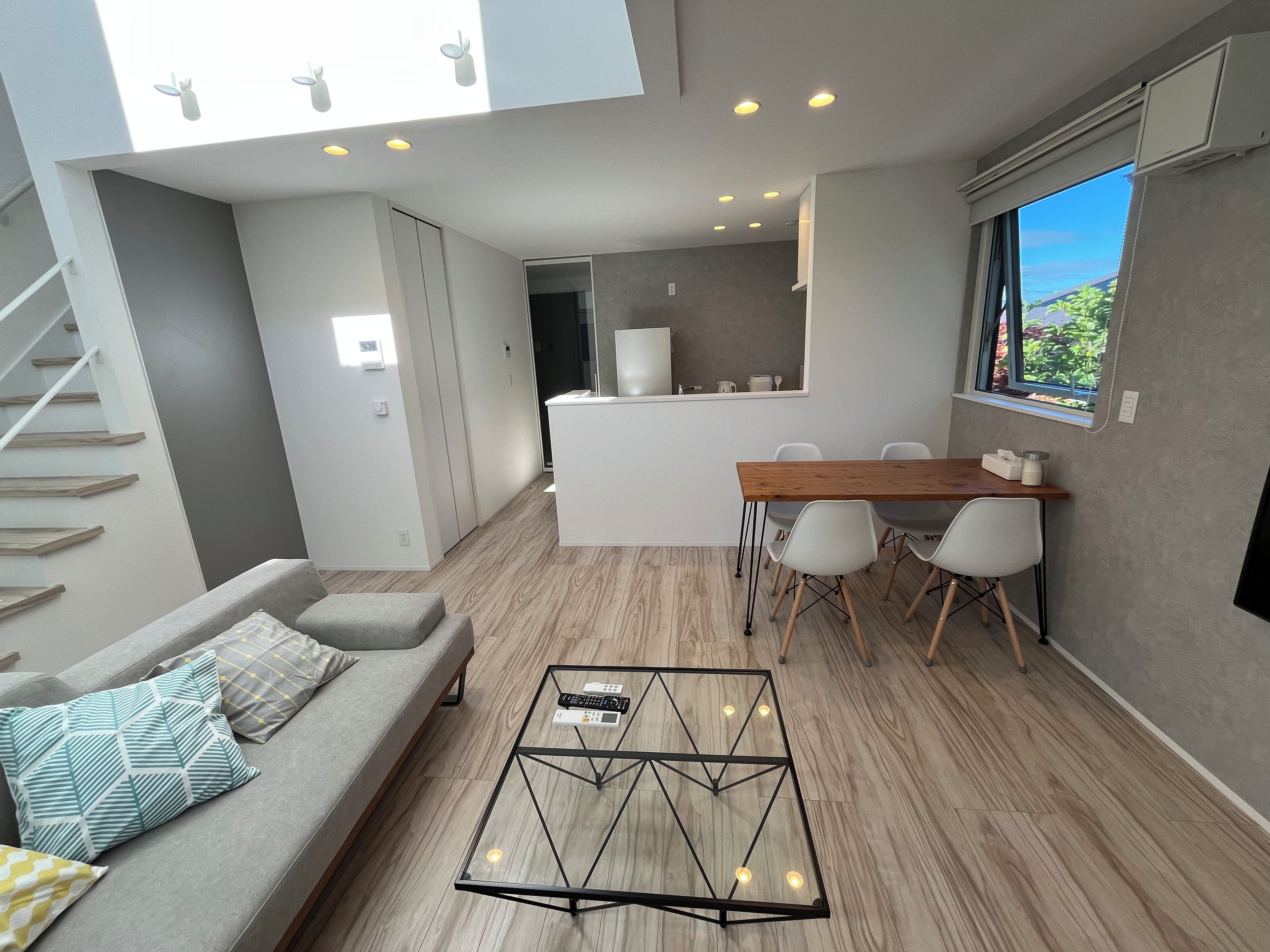 A modern interior with a sofa, coffee table, dining table, and chairs.
