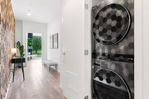 Un intérieur moderne avec un espace cuisine doté d’un revêtement mural en carreaux hexagonaux originaux, d’un banc et d’une vue sur l’extérieur.