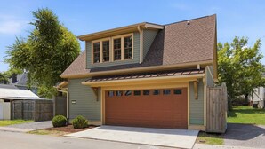 A two-story house with a garage, a front yard, and a driveway.