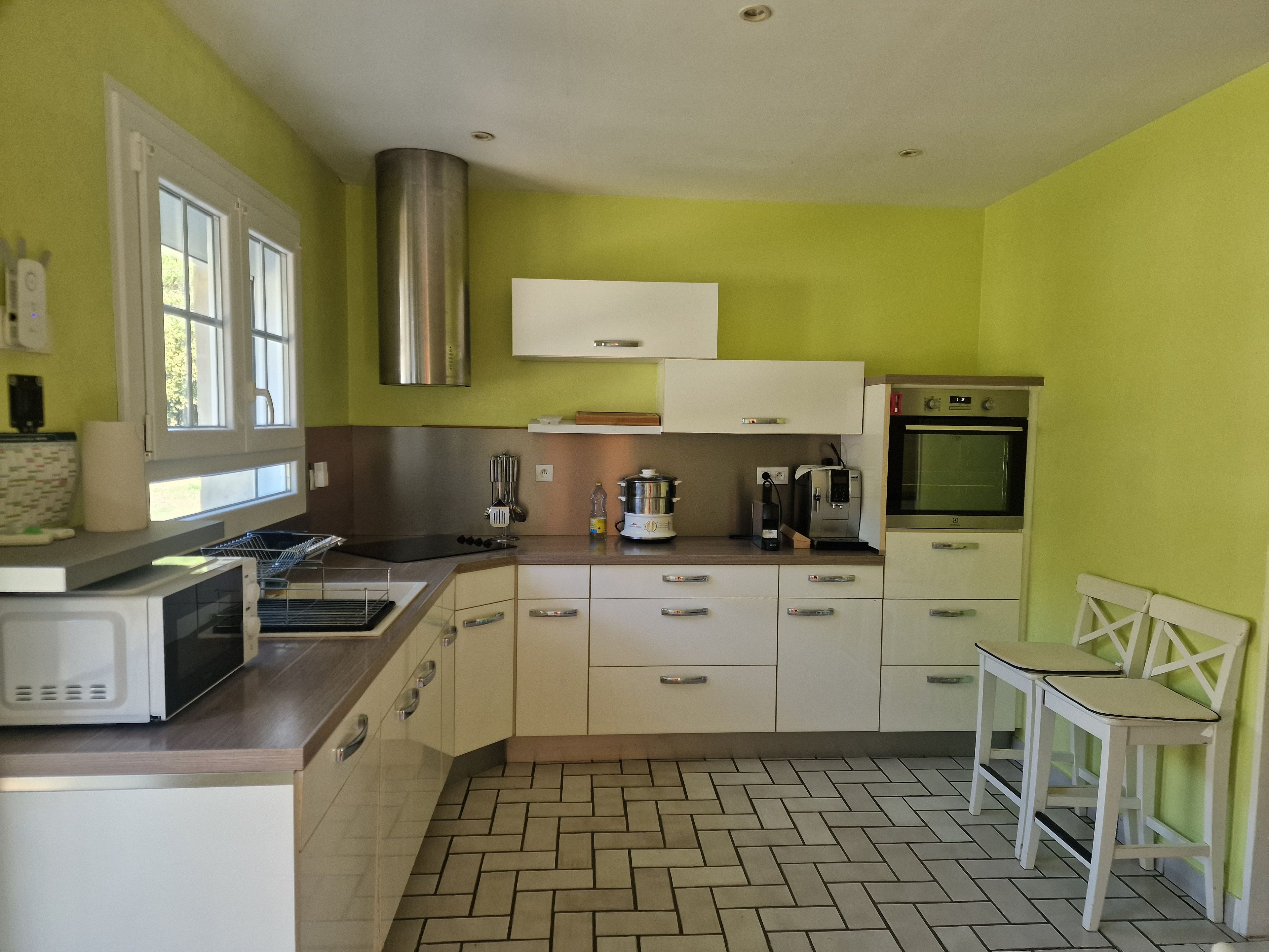A kitchen with white cabinets, a microwave, a coffee maker, and a stove.