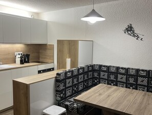 Eine moderne Küche mit einer Holzarbeitsplatte, einem Wasserkocher und einer Kaffeemaschine.