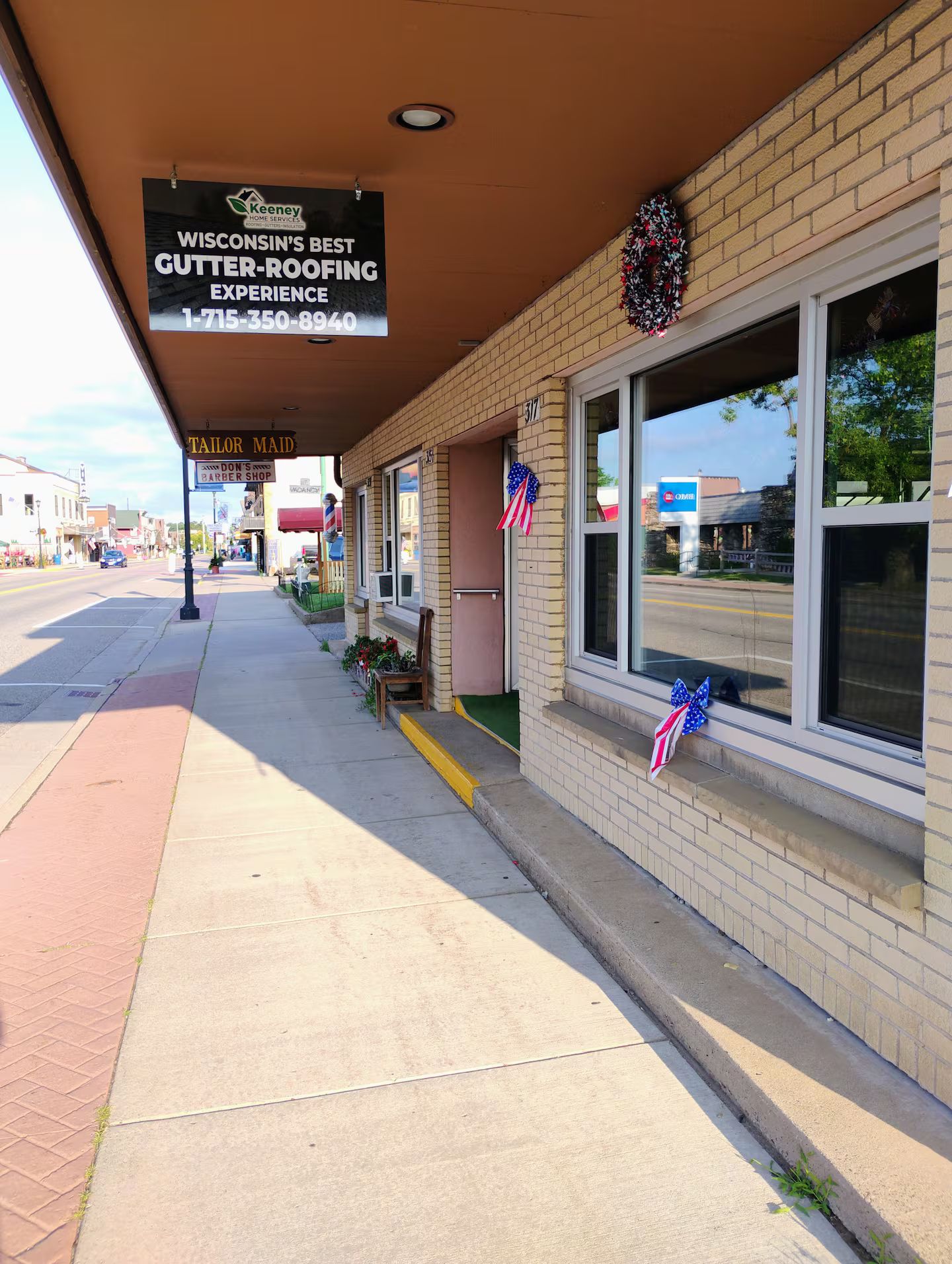 A storefront with a sign for gutter-ROOFING EXPERIENCE.