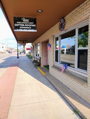 A storefront with a sign for gutter-ROOFING EXPERIENCE.