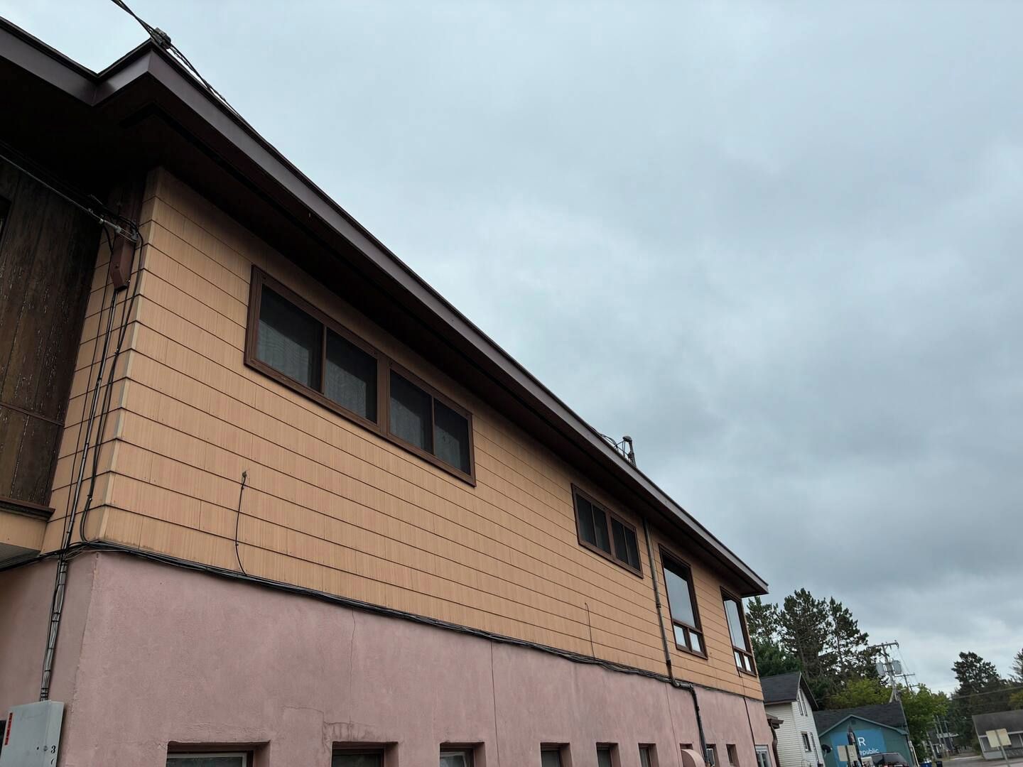 En byggnad med flera våningar, ett platt tak och en rosa fasad.