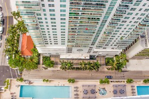 A high-rise building with multiple balconies, a swimming pool, and palm trees. - Cozy 1 bedroom apartment in vibrant center of Brickell!! (Miami)