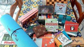 Une variété de jeux de société et un tapis de yoga sur une nappe à motifs.