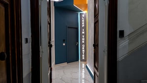 Un couloir avec une pancarte indiquant « DORMEZ AU CENTRE » et un sol en marbre.
