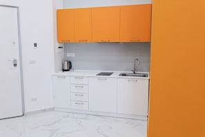 A compact kitchen with white cabinets, a sink, and a coffee maker. - SUN SUITE - LUXURY APARTMENT IN THE CENTER (Napoli)