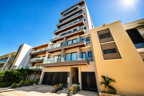 Un edificio residencial de varios pisos con un diseño moderno, con balcones y ventanas amplias.