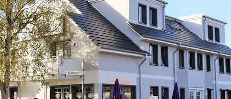 A two-story building with a storefront and outdoor seating area.