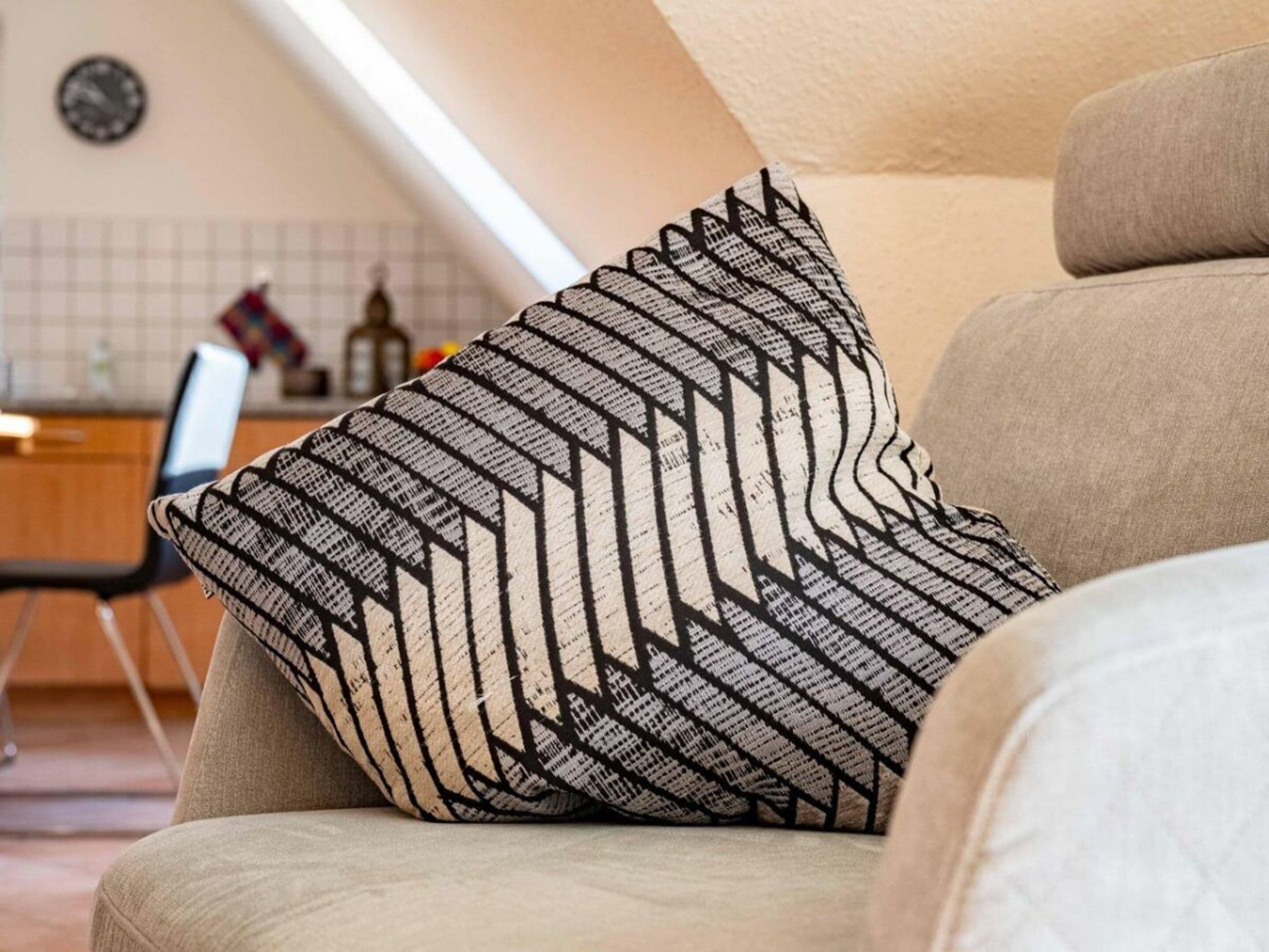 En stue med en sofa og et mønstret pude.