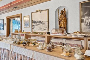 Mesa de buffet com diversos alimentos e uma estátua.