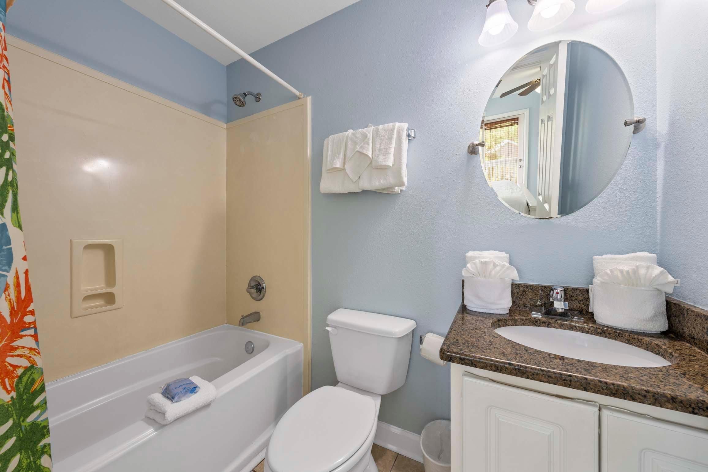 Un baño con bañera, inodoro y lavamanos.