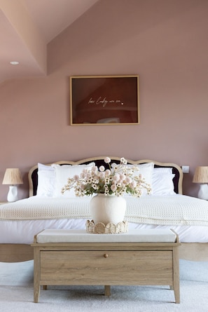 A bedroom with a bed, bedside lamps, a bedside table with a vase of flowers, and a framed quote on the wall. - Preseli Heights Luxury Indoor Pool House with Cinema & Bar (Llanreath)