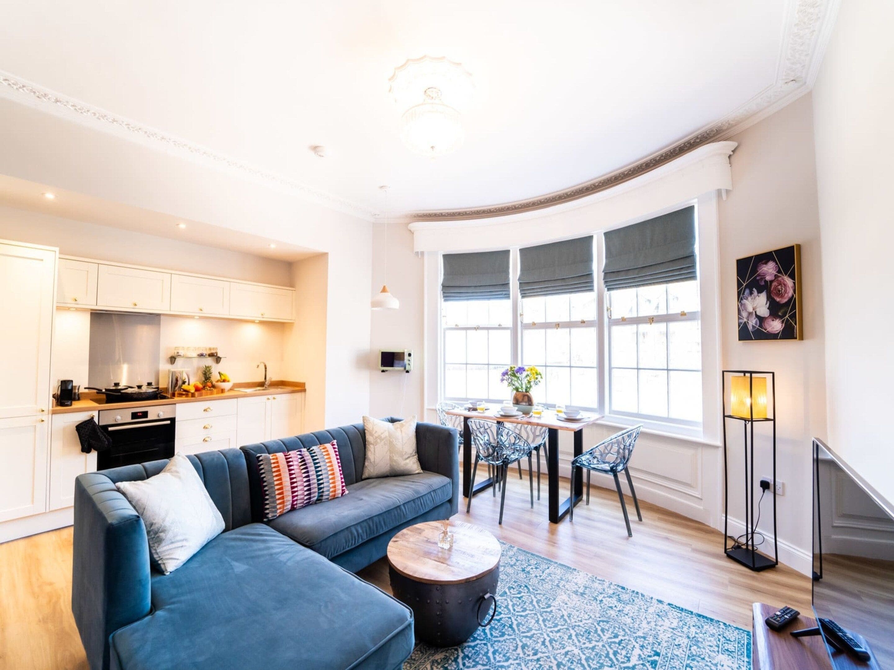 A modern living room with a sofa, coffee table, and dining area.