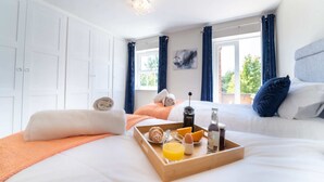 Een hotelkamer met een bed, een dienblad met ontbijtartikelen en uitzicht op groen.