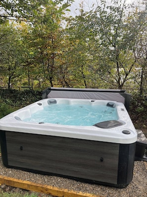 Ein Whirlpool im Freien, umgeben von Bäumen.
