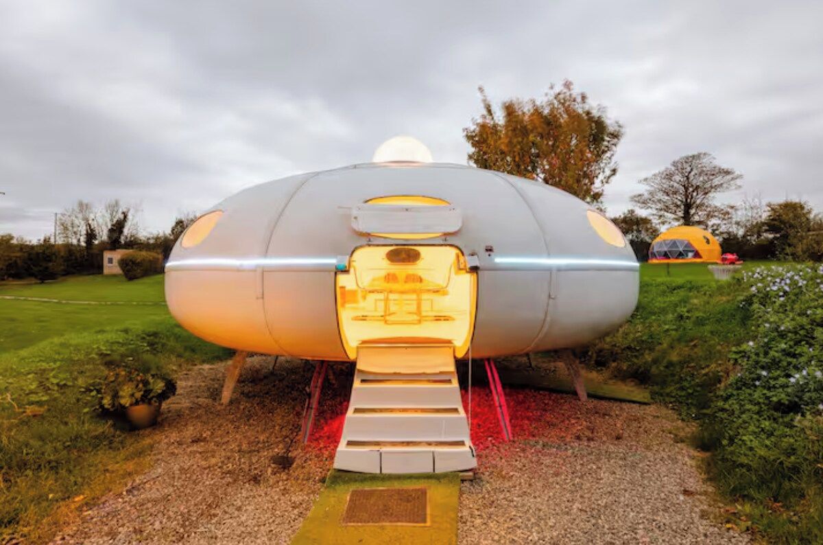 A futuristic, dome-shaped structure with a central entrance and a small platform leading up to it.