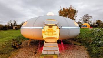 A futuristic, dome-shaped structure with a central entrance and a small platform leading up to it.