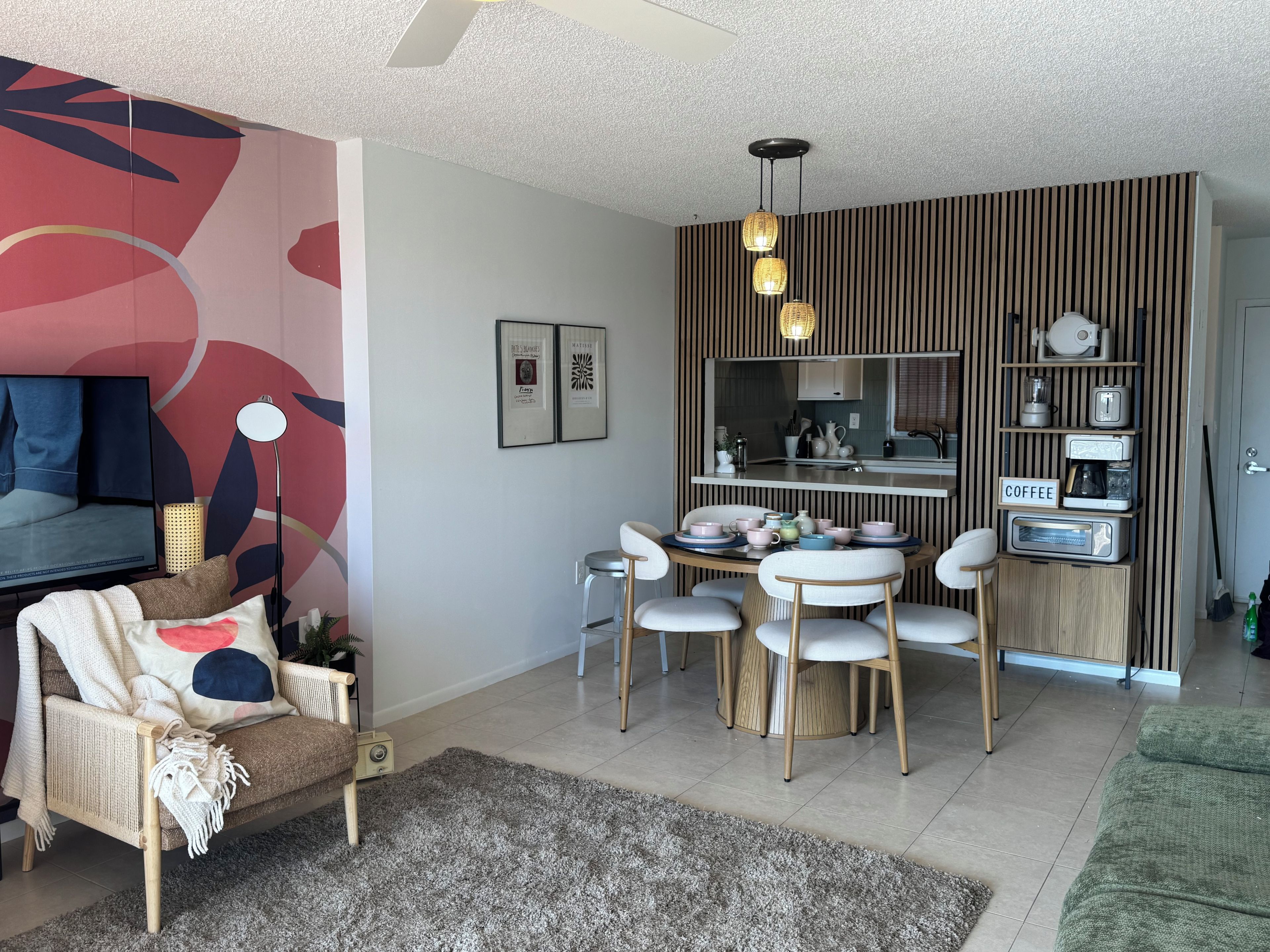 A modern living room with a sofa, a coffee table, and a dining area with chairs.