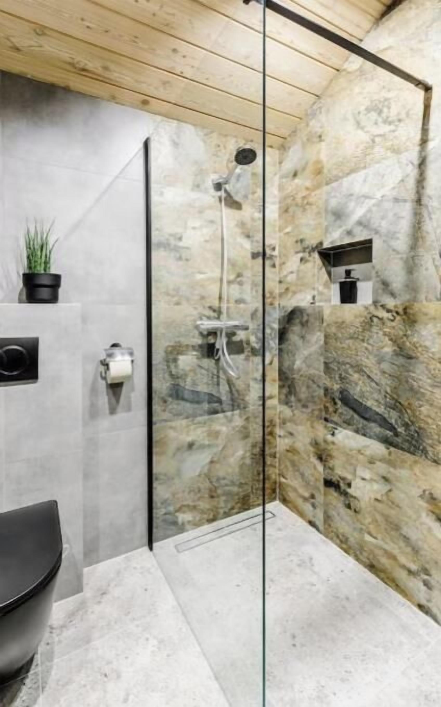 Une salle de bain moderne équipée d’une douche, de toilettes et d’un lavabo.