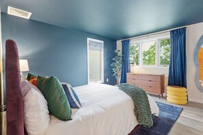 Une chambre à coucher avec un lit, une fenêtre, une plante et une table de chevet.