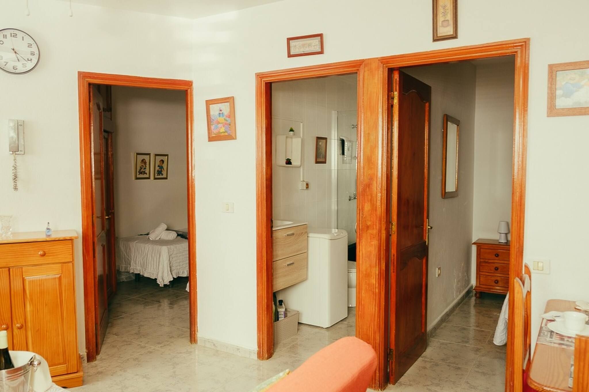 Ein Zimmer mit einem Bett, einem kleinen Badezimmer und einer Holztür.