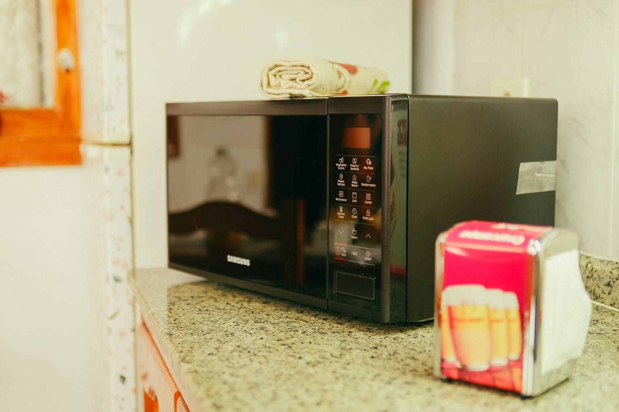 Un four à micro-ondes noir doté d’un panneau de commande numérique, posé sur un plan de travail de cuisine.