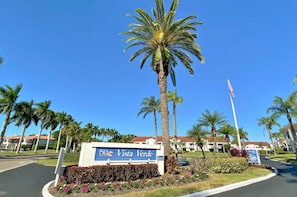 A sign for Vista Verde with palm trees and a clear blue sky. - Vista Verde East 105 (St. Petersburg)