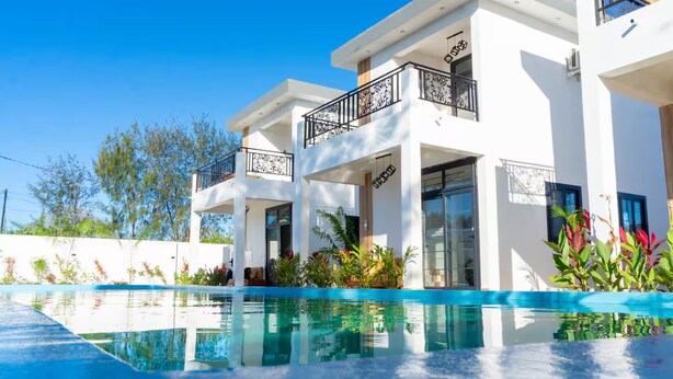 Un bâtiment moderne à deux étages avec une piscine à l’avant.