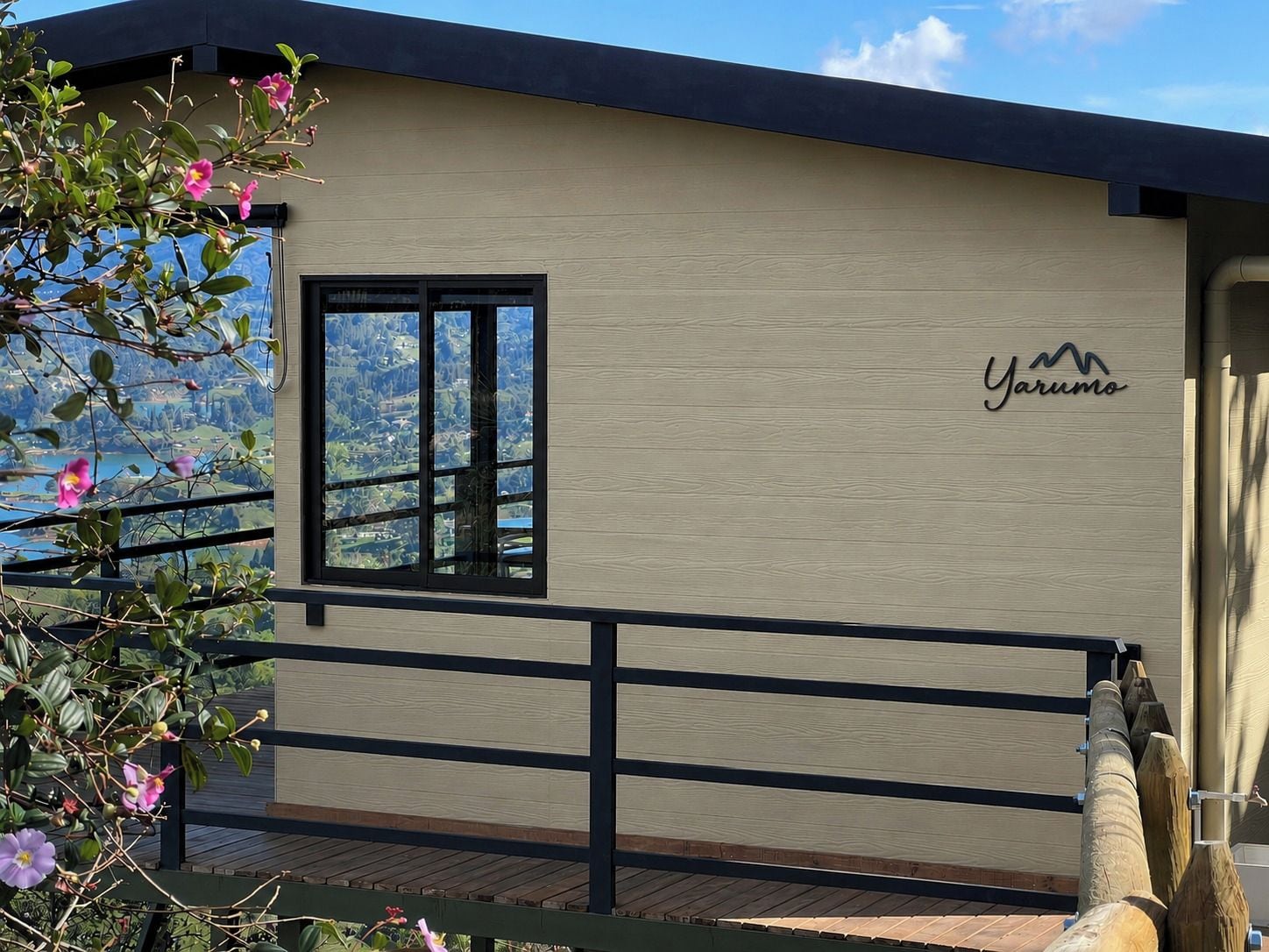 Un bâtiment doté d’une terrasse en bois, d’une fenêtre et d’une enseigne sur laquelle on peut lire « Yarumo ».