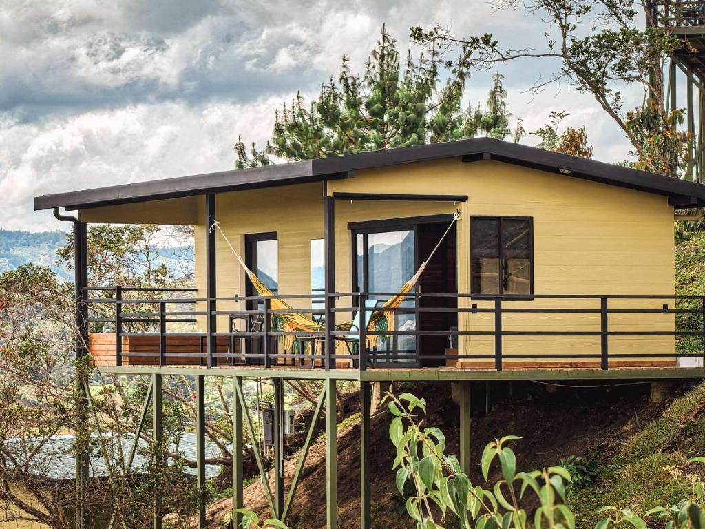 Een modern huis met een balkon, een houten terras en uitzicht op het omliggende landschap.