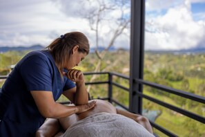 A massage therapy session taking place in a room with a view of a mountainous landscape. - Alto Sereno (El Peñol)