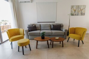 A living room with a sofa, two yellow armchairs, two round coffee tables, and a potted plant. - Luxury Sea-View Villa with Private Pool & Coastal Charm in Larnaca. Book now! (Sophtadhes)