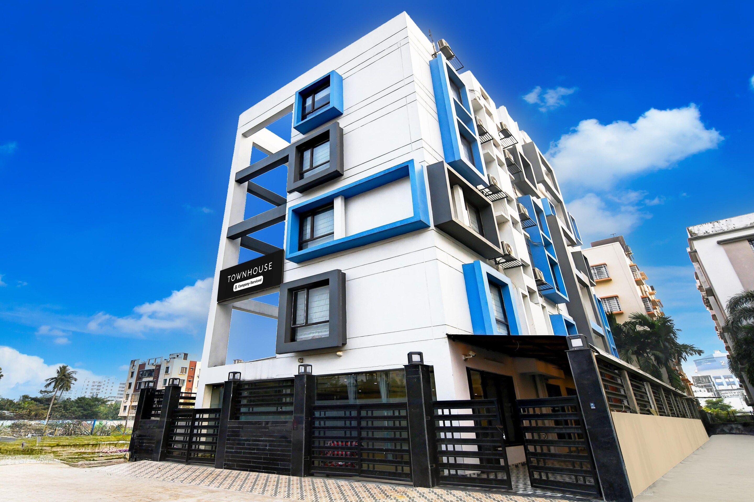 A modern multi-story building with a sign indicating it is a townhouse.