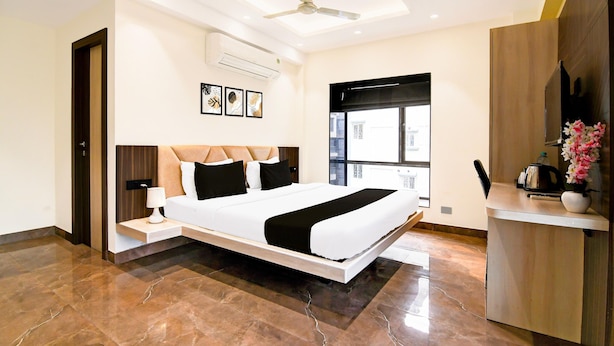 Una habitación de hotel moderna con una cama grande, un escritorio y un ventilador de techo.