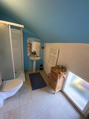 Een badkamer met toilet, wastafel en douche.