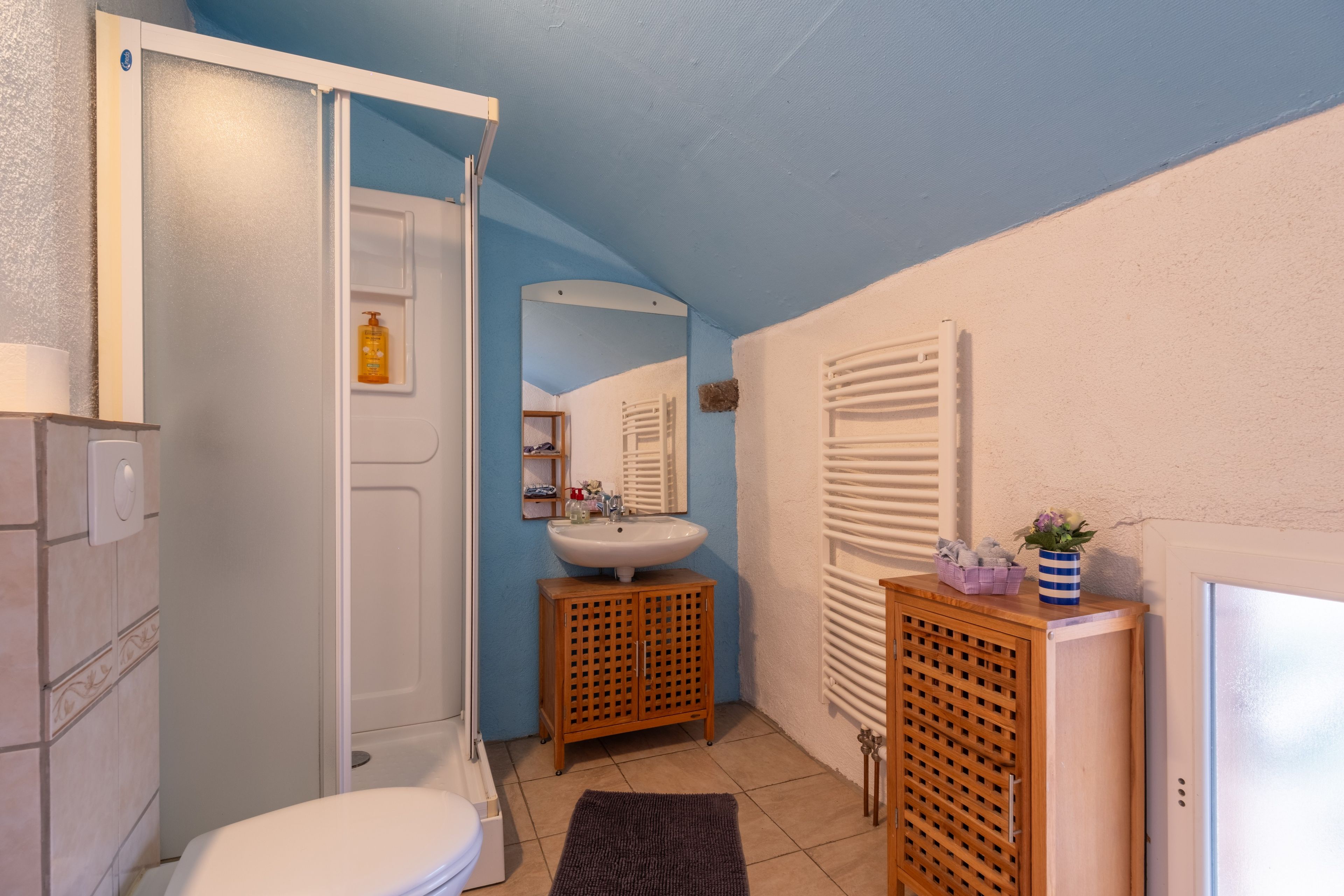 Une salle de bain comprenant des toilettes, un lavabo et un espace douche.