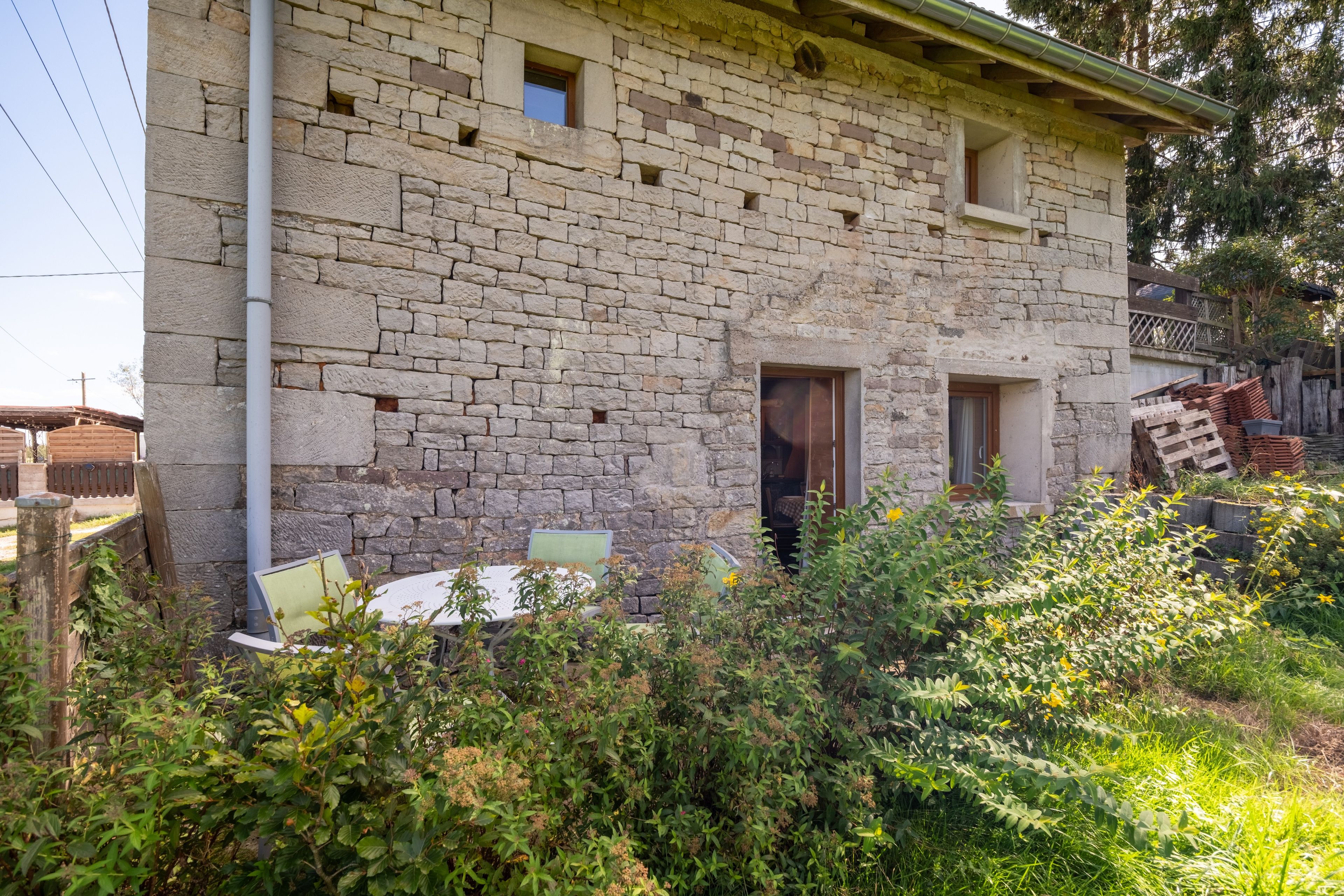 Un bâtiment en pierre doté d’un petit balcon, d’une fenêtre et d’une porte.
