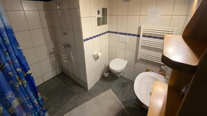 A bathroom with a shower, toilet, and sink. - Apartment 'Maison Du Bonheur - Appartement' with Mountain View, Private Terrace and Wi-Fi (Xertigny)