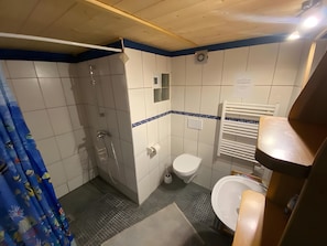 Ein Badezimmer mit Dusche, Toilette und Waschbecken.