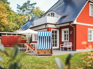 A red house with a blue roof, a white porch, and a striped beach umbrella. - Holiday Home With 3 Bedrooms (Ostseebad Prerow)