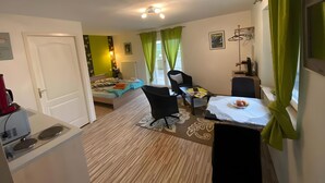 Une chambre d’hôtel de taille réduite, comprenant un lit, un bureau, une chaise et une petite table.