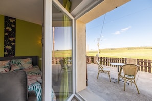 A room with a bed, a window, and a view of a golf course.