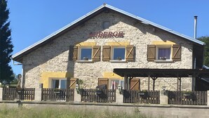 A stone building with a sign reading 'AUBERGE' and a wooden fence in front. - Guest Room "Double Room - Petit moulin" with Mountain View, Shared Terrace and Wi-Fi (Xertigny)