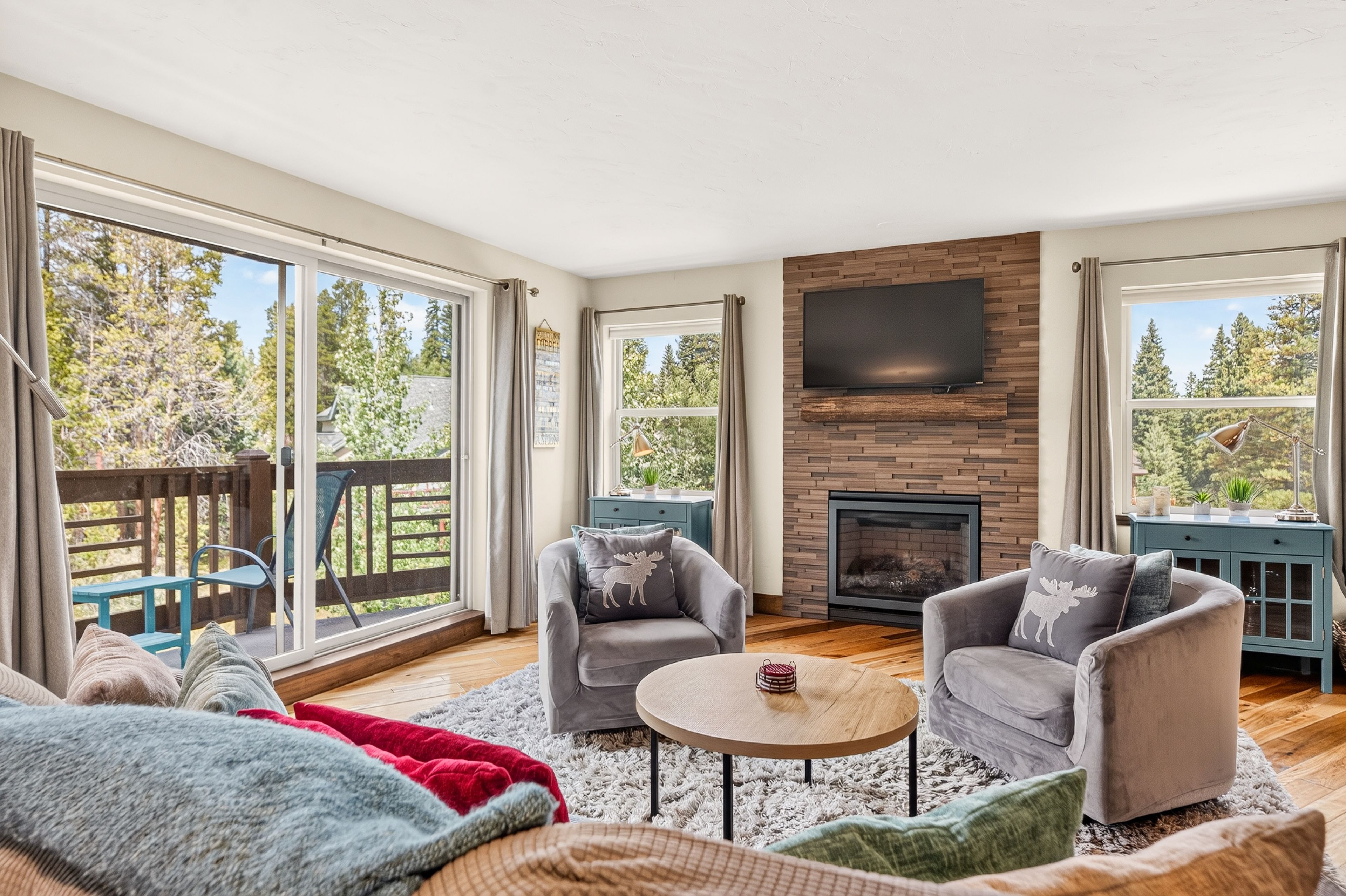 Un salón amplio con chimenea, ventanas grandes y vistas al exterior.