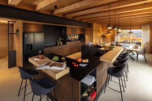 Une cuisine moderne dotée d’un îlot central, de tabourets de bar et d’un coin repas offrant une vue agréable.