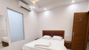 Quarto com cama, guarda-roupa, janela e ar condicionado.