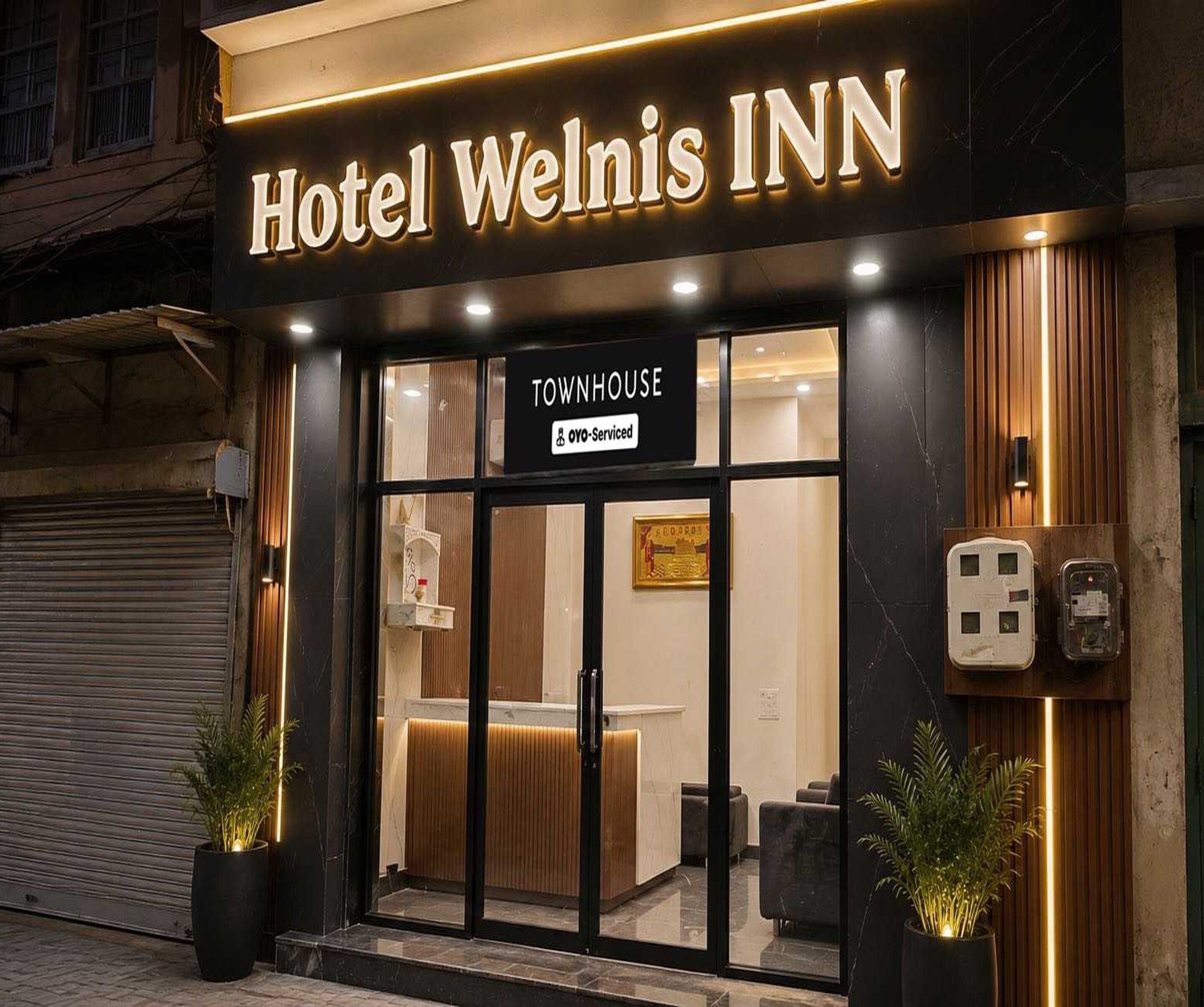 Hotel Welnis INN con un letrero que indica 'TOWNHOUSE', indicando un tipo específico de alojamiento.