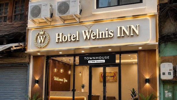 Hotel Welnis Inn com uma placa 'Townhouse', uma receção e uma placa 'Welcome You'.